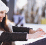 Young woman ice skating on a rink in a city center - Городская Газета